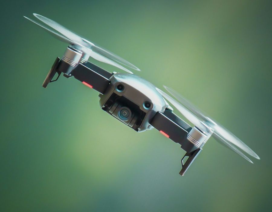 A compact drone against a green background